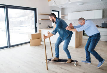 Two cheerful men having fun when furnishing new house, a new home concept. - HPIF23545