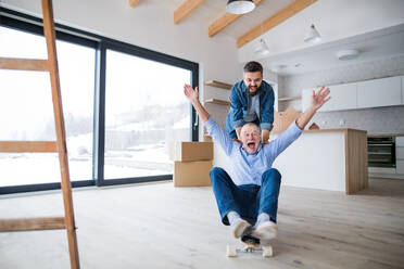 Two cheerful men having fun when furnishing new house, a new home concept. - HPIF23546