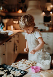 Ein glücklicher Junge im Kleinkindalter, der in der Küche zu Hause Kuchen backt. - HPIF23587