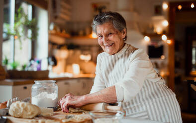 Eine ältere Frau, die zu Hause in einer Küche Kuchen backt. Kopierraum. - HPIF23602