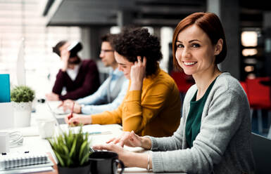 Eine Gruppe junger Geschäftsleute mit Computern und VR-Brillen, die im Büro zusammenarbeiten. Kopierraum. - HPIF23640