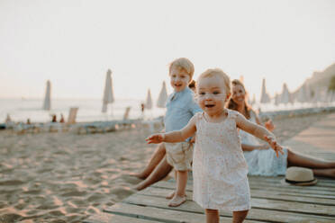 Eine junge Familie mit Kleinkindern, die sich im Sommerurlaub am Strand vergnügen. - HPIF23815