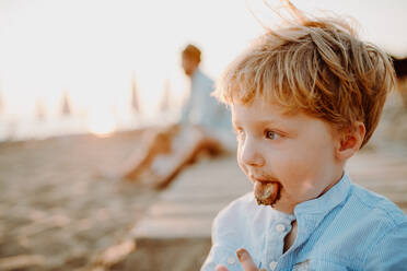 A small toddler boy on beach on summer holiday, sticking out tongue. Copy space. - HPIF23817