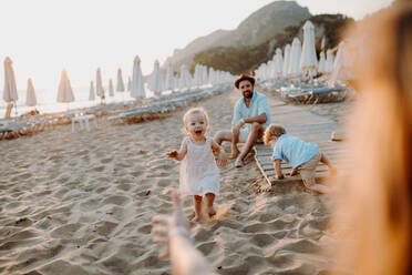 Eine junge Familie mit Kleinkindern, die sich im Sommerurlaub am Strand vergnügen. - HPIF23818