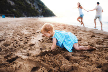 Ein kleines Mädchen spielt im Sand am Strand im Sommerurlaub. - HPIF23872