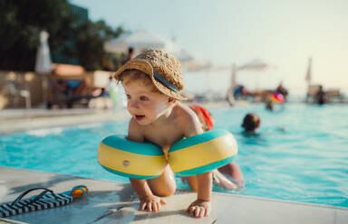 A happy small toddler boy with armbands and his mother swimming in water on summer holiday. - HPIF23932