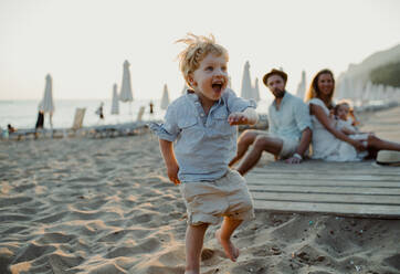 Eine junge Familie mit Kleinkindern, die sich im Sommerurlaub am Strand vergnügen. - HPIF23941