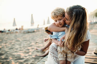 Young mother with a toddler boy having fun on beach on summer holiday. Copy space. - HPIF23944