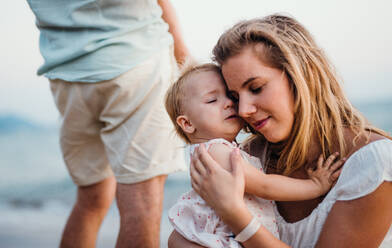 Eine Nahaufnahme einer jungen Mutter mit einem Kleinkind am Strand im Sommerurlaub. - HPIF23965