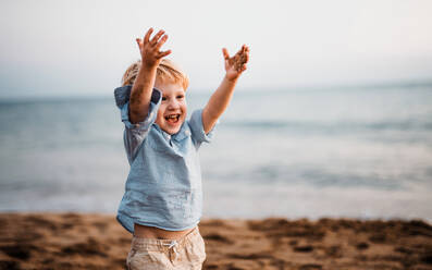 Ein fröhlicher kleiner Junge am Strand im Sommerurlaub, der Spaß hat. - HPIF23972