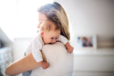 A beautiful young mother holding a newborn baby at home. Copy space. - HPIF24069