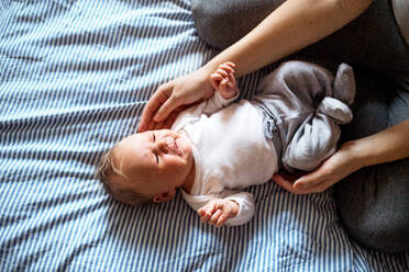 A midsection of unrecognizable mother holding a newborn baby at home. - HPIF24071