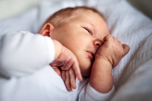Eine Nahaufnahme eines süßen schlafenden Neugeborenen zu Hause. - HPIF24085
