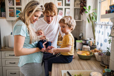 Junge Eltern mit einem neugeborenen Baby und einem kleinen Kleinkind zu Hause. - HPIF24109