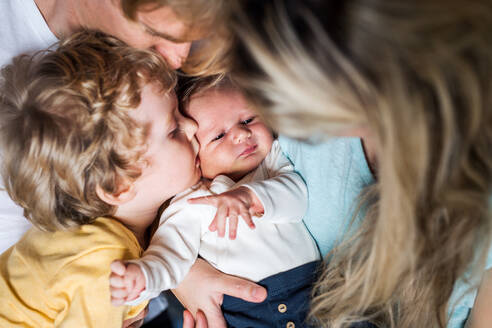 Junge Eltern mit einem neugeborenen Baby und einem kleinen Kleinkind zu Hause, eine Nahaufnahme. - HPIF24127
