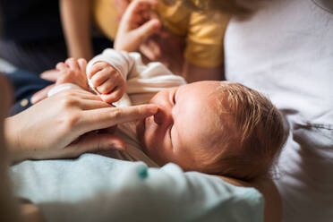 Ein Mittelteil von Eltern mit neugeborenem Baby und kleinem Kleinkindsohn zu Hause. - HPIF24129