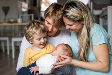 Young parents with a newborn baby and small toddler son at home. - HPIF24132