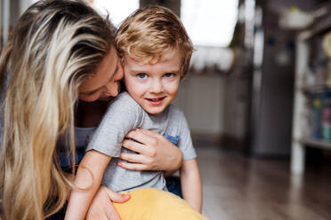 A happy mother with a toddler son indoors at home, playing. Copy space. - HPIF24186