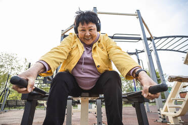 Lächelnde ältere Frau, die im Park trainiert - ADF00096