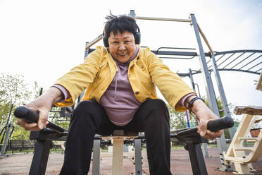 Smiling senior woman working out at park - ADF00096