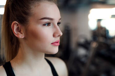 A portrait of a beautiful young girl or woman standing in a gym. Copy space. - HPIF24350
