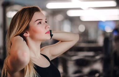 A portrait of a beautiful young girl or woman standing in a gym. Copy space. - HPIF24355