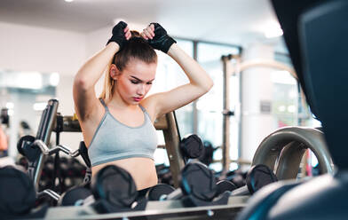 Ein Porträt eines schönen jungen Mädchens oder einer Frau, die in einem Fitnessstudio trainiert. - HPIF24363