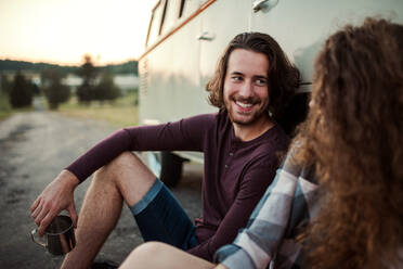 Ein junges Paar auf einem Roadtrip durch die Landschaft, das in einem Retro-Minivan sitzt. - HPIF24782