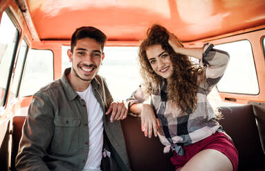 A young couple on a roadtrip through countryside, driving retro minivan. - HPIF24825