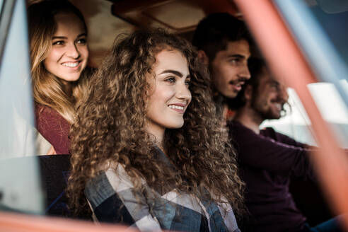 A group of young friends on a roadtrip through countryside, sitting in a retro minivan. - HPIF24839
