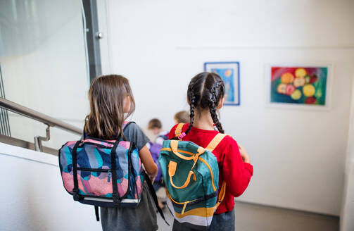 Rückansicht von kleinen Schulmädchen mit Taschen, die die Treppe hinuntergehen. Back to school Konzept. - HPIF24946