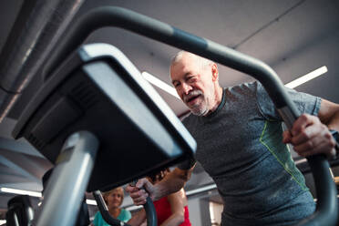 Ein älterer Mann beim Krafttraining in der Turnhalle, ein Kopierraum. - HPIF25055