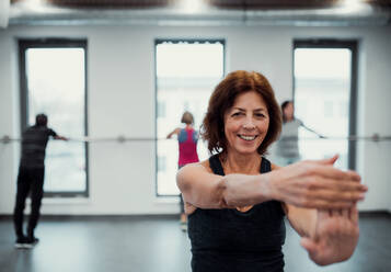 Eine fröhliche ältere Frau in einem Fitnessstudio, die Übungen macht. Raum kopieren. - HPIF25091