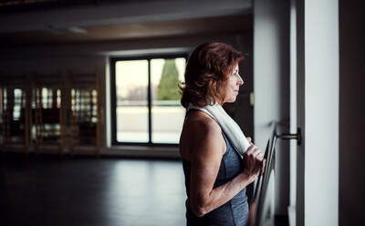 Eine zufriedene ältere Frau in einem Fitnessstudio, die sich nach dem Training ausruht. Platz kopieren. - HPIF25118