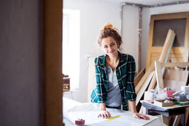 Small business of a young woman. Beautiful young woman worker in workroom. - HPIF25144