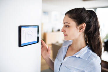 A woman looking at tablet with smart home control system. - HPIF25227