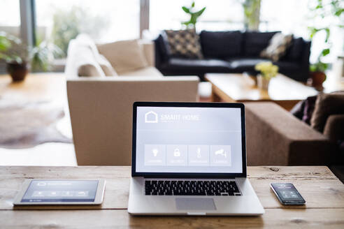 Ein Laptop, ein Tablet und ein Telefon mit einem intelligenten Haussteuerungssystem. - HPIF25233