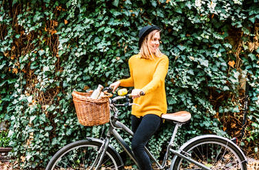 Young beautiful woman with bicycle in sunny spring nature. - HPIF25286