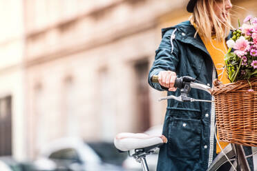 Junge Frau mit Fahrrad in einer sonnigen Frühlingsstadt, Raum kopieren. - HPIF25305