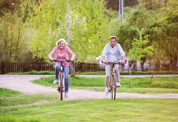 Schönes älteres Paar mit Fahrrädern draußen im Frühling in der Natur Radfahren. - HPIF25391