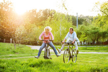 Schönes älteres Paar mit Fahrrädern Radfahren im Freien im Frühling Natur, Spaß haben. - HPIF25392