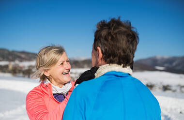 Älteres Paar joggt draußen in der winterlichen Natur und ruht sich aus. - HPIF25454