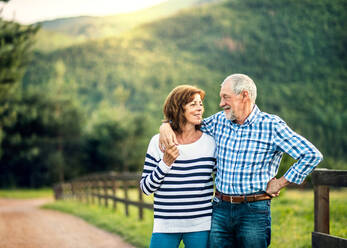 A joyful senior couple in love looking at each other outside in nature. Copy space. - HPIF25525