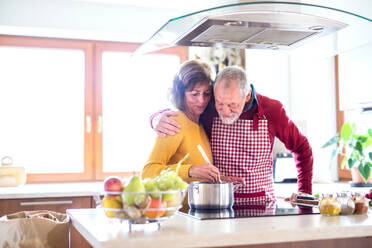 Älteres Ehepaar bei der Zubereitung von Speisen in der Küche. Ein alter Mann und eine Frau im Haus beim Kochen. - HPIF25553