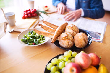 Unrecognizable senior couple eating breakfast at home. An old man and woman sitting at the table, relaxing. - HPIF25567