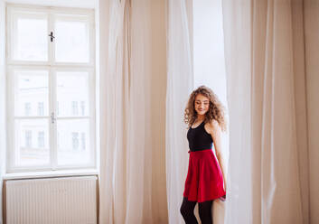 Porträt einer jungen Tanzlehrerin, die drinnen am Fenster steht, Kopierraum. - HPIF25663