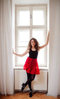 Porträt einer jungen Tanzlehrerin, die drinnen am Fenster steht, Kopierraum. - HPIF25664