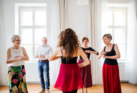 Eine Gruppe älterer Menschen besucht einen Tanzkurs mit einem Tanzlehrer. - HPIF25670