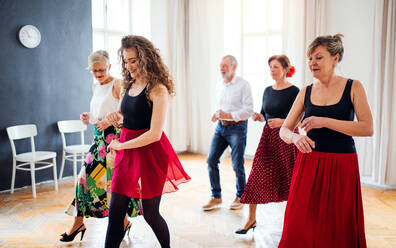 Eine Gruppe älterer Menschen besucht einen Tanzkurs mit einem Tanzlehrer. - HPIF25671