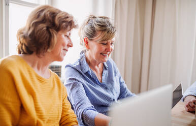 Senior women using laptops and tablets in community center club, technology in everyday life concept. - HPIF25786